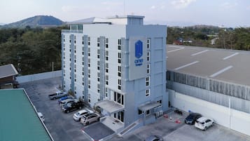 A multi-story building with a parking lot in front.