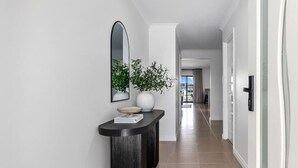 A modern hallway with a black console table, a mirror, and a potted plant. - Casa Cumpari in Wannanup (Wannanup)