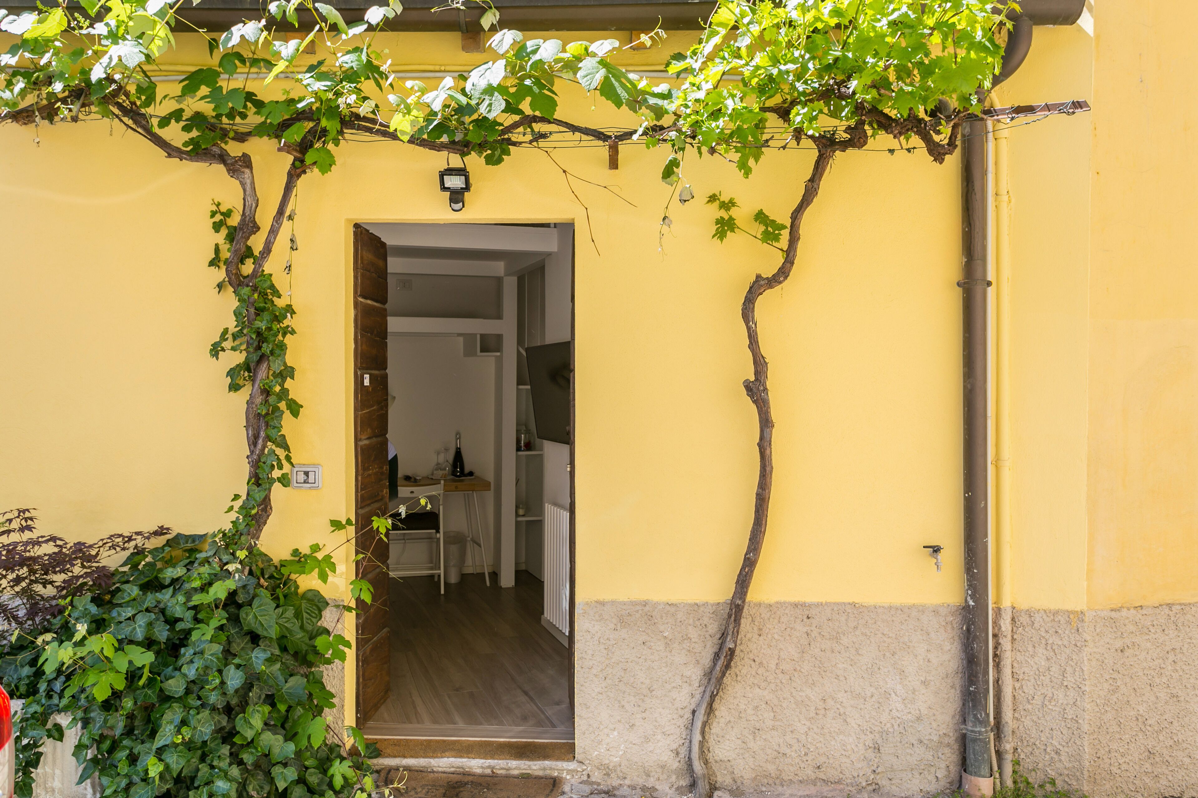 A doorway leading into a room with a wooden floor and a white table.