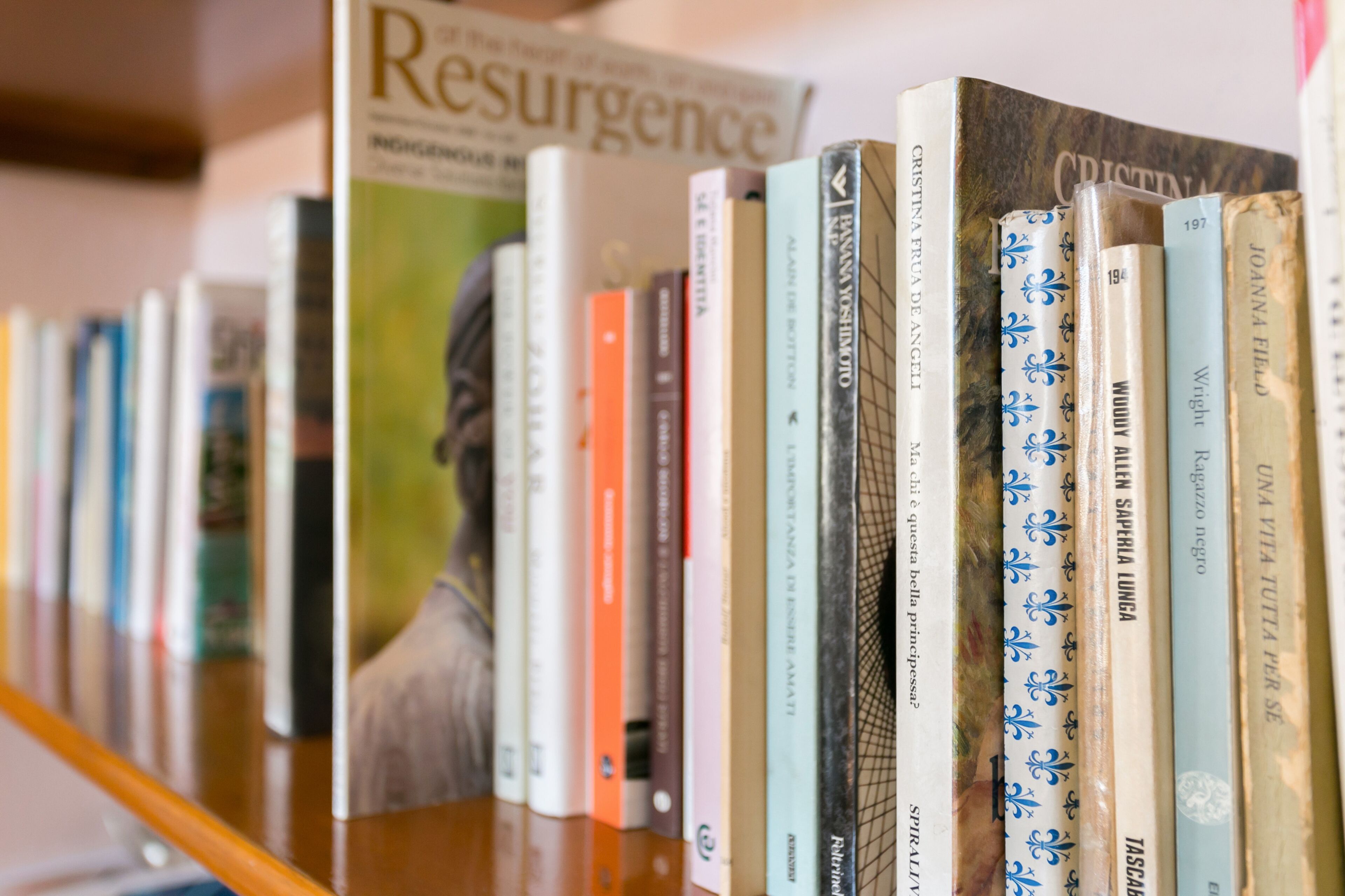 Una estantería con varios libros, incluyendo títulos como "Resurgence" y "Cristina".