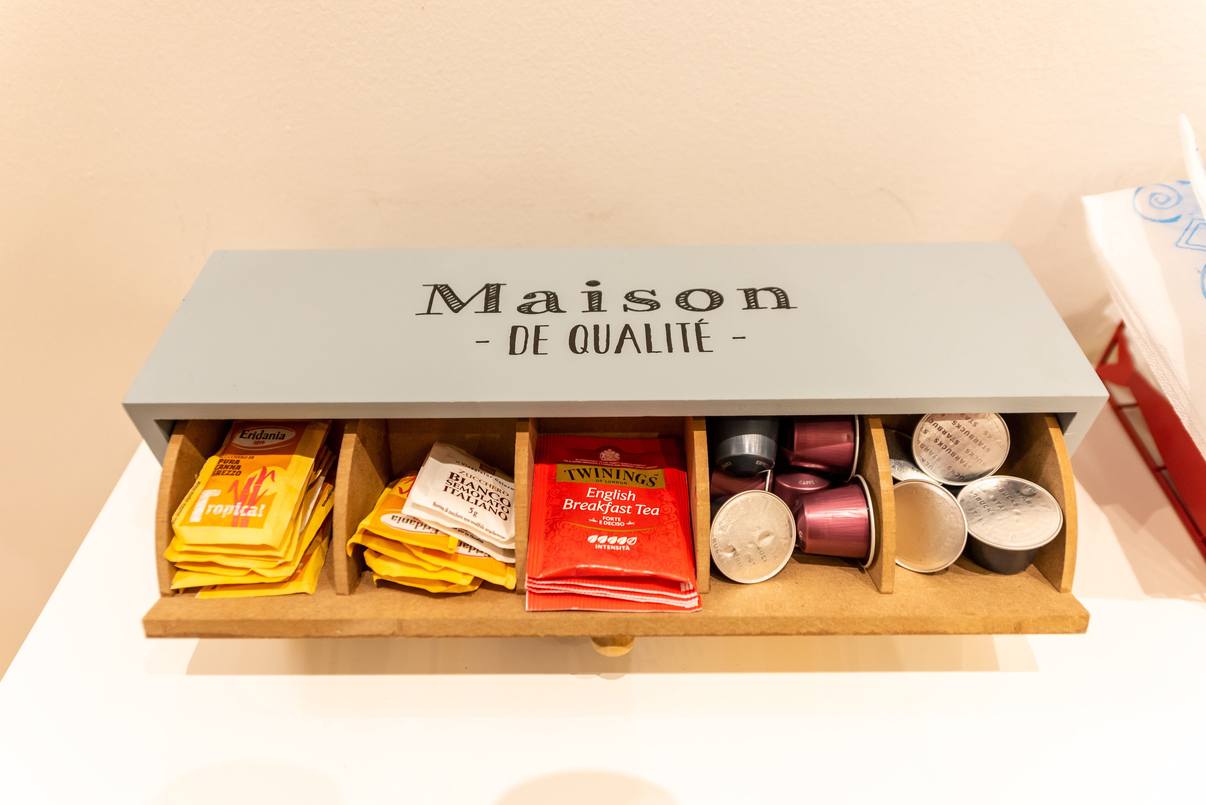 Un tiroir contenant divers produits à base de thé, notamment le thé English Breakfast de la marque Twinings et le thé tropical de la marque Eridania.