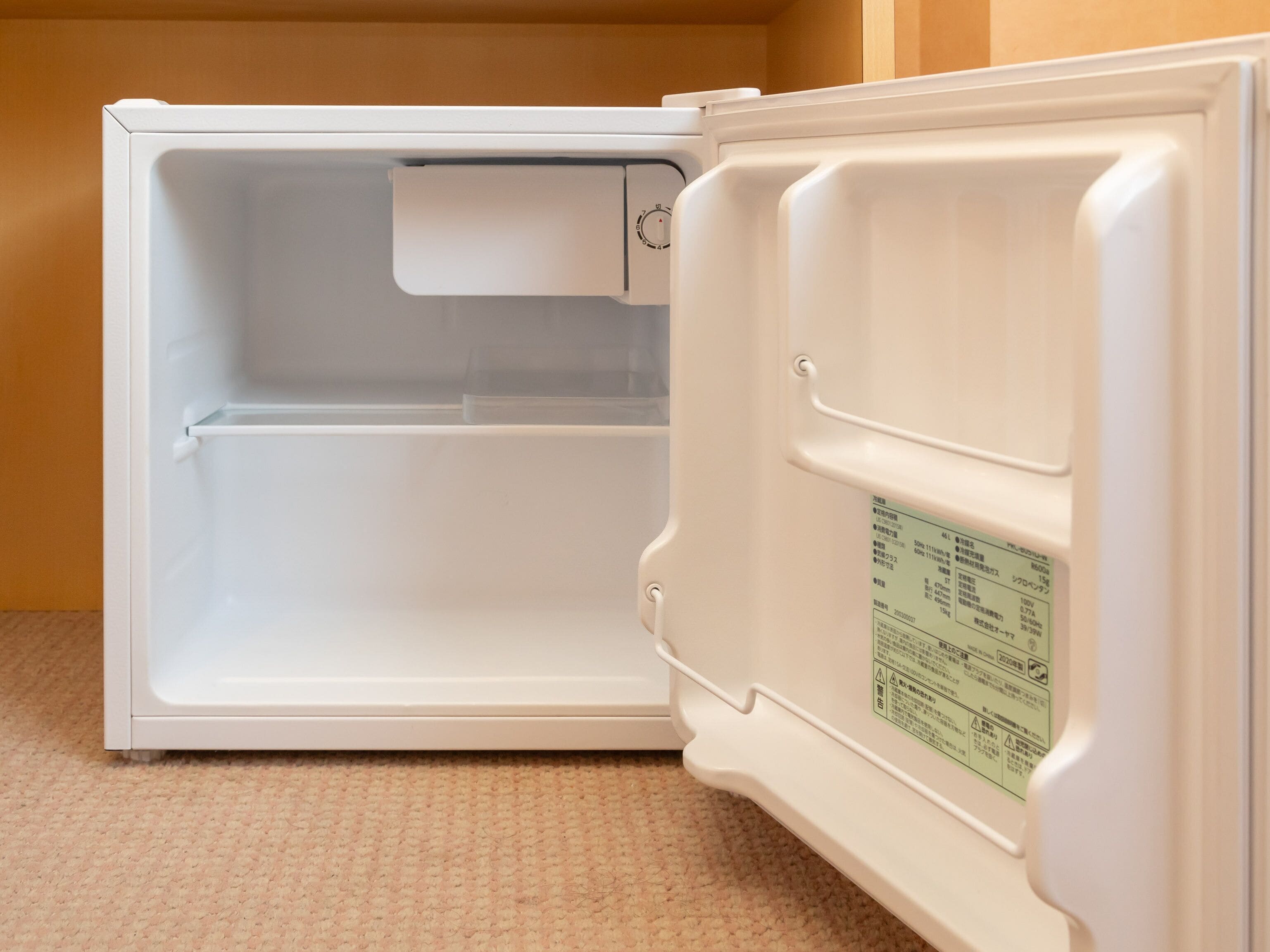 An open refrigerator with a control panel and a label on the door.