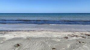Une plage avec un ciel dégagé et une mer calme.