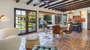 A spacious patio with a dining area, a kitchen, and a view of the outdoors.