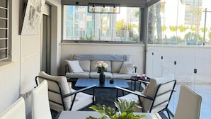 A modern outdoor seating area with a table, chairs, and a potted plant. - Groundfloor GreenHills Villamartin, Orihuela Costa (Villamartín)