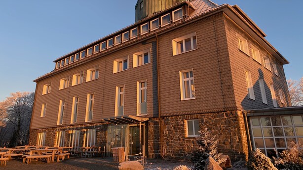 A large, multi-story building with a stone facade and multiple windows.