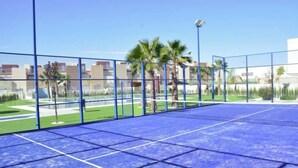 Ein Hallen-Tennisplatz mit blauer Belag und Netz.