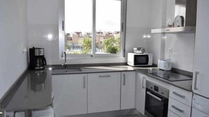 A modern kitchen with a large window, a microwave, and a coffee maker.