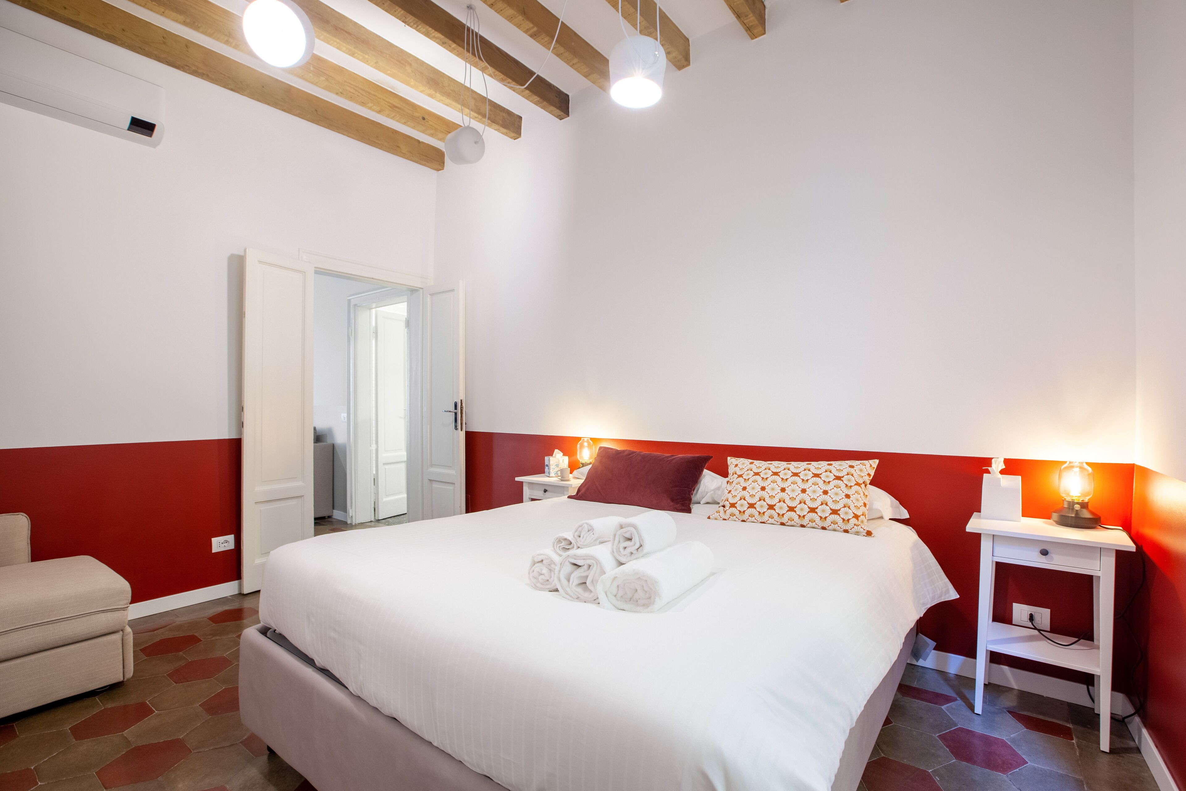 A hotel room with a bed, a nightstand, a chair, and a door.