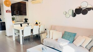 Ein modernes Wohnzimmer mit einer Couch, einem Couchtisch und einem Essbereich mit Stühlen und einem Tisch.