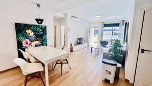 Ein modernes Wohnzimmer mit Essbereich, einem Fernseher und einem großen Fenster mit Blick.