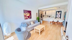 Ein modernes Wohnzimmer mit einer Couch, einem Couchtisch und einem Essbereich mit Stühlen und einem Tisch.