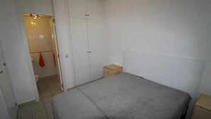 A bedroom with a bed, a wardrobe, and a small wooden stool. - Apartment Playa Flamenca  resd. Playa Terrazas (Orihuela Costa)