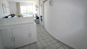 A modern, white interior with a kitchen area, a dining space, and a living area with a view. - Apartment Playa Flamenca  resd. Playa Terrazas (Orihuela Costa)