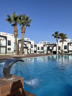 Relax by the pool surrounded by palm trees in a serene oasis.
