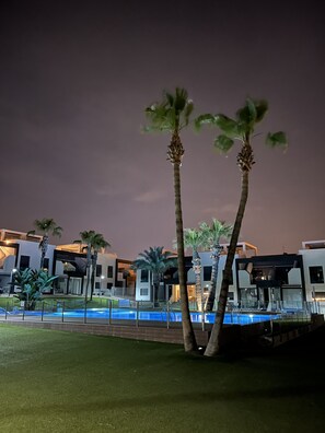 Relax by the pool surrounded by lush palm trees and modern hotel architecture.