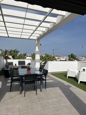 Relax in a serene outdoor space with a glass-top table and comfortable seating.