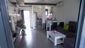 Un appartement moderne comprenant un salon, une cuisine et un coin repas.