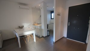 A modern kitchen with white cabinets, a dining table with chairs, and a black door. - Ground floor Oasis Beach II La Zenia (La Zenia)