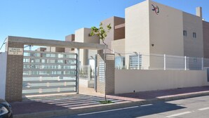 Un immeuble résidentiel fermé, doté d’une entrée bien définie, d’une enseigne visible indiquant l’adresse et d’une grille de sécurité.