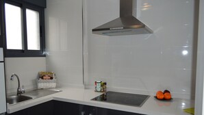 Une cuisine équipée d’un évier, d’une cuisinière et d’une fenêtre.