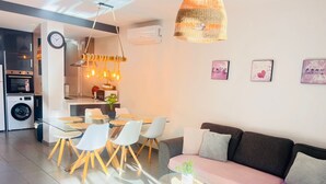 Une cuisine moderne avec un coin repas, un canapé et une petite table agrémentée d’une plante.