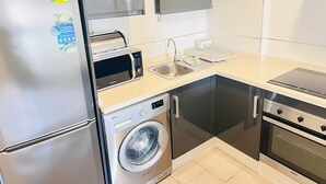 A modern kitchen with a built-in dishwasher, a microwave, a sink, and a stove.