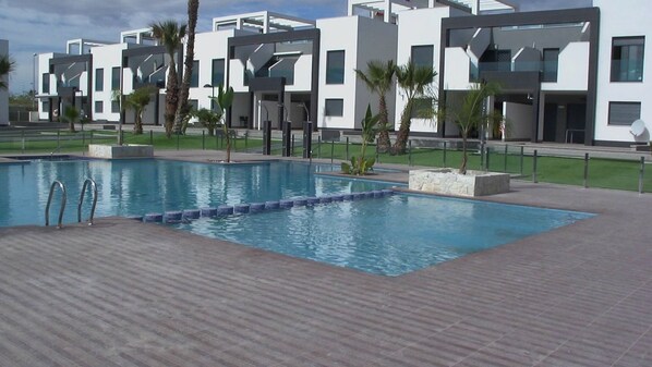 A modern pool area with a rectangular pool, metal ladders, and a tiled deck. - Penthouse Oasis beach V La zenia (La Zenia)