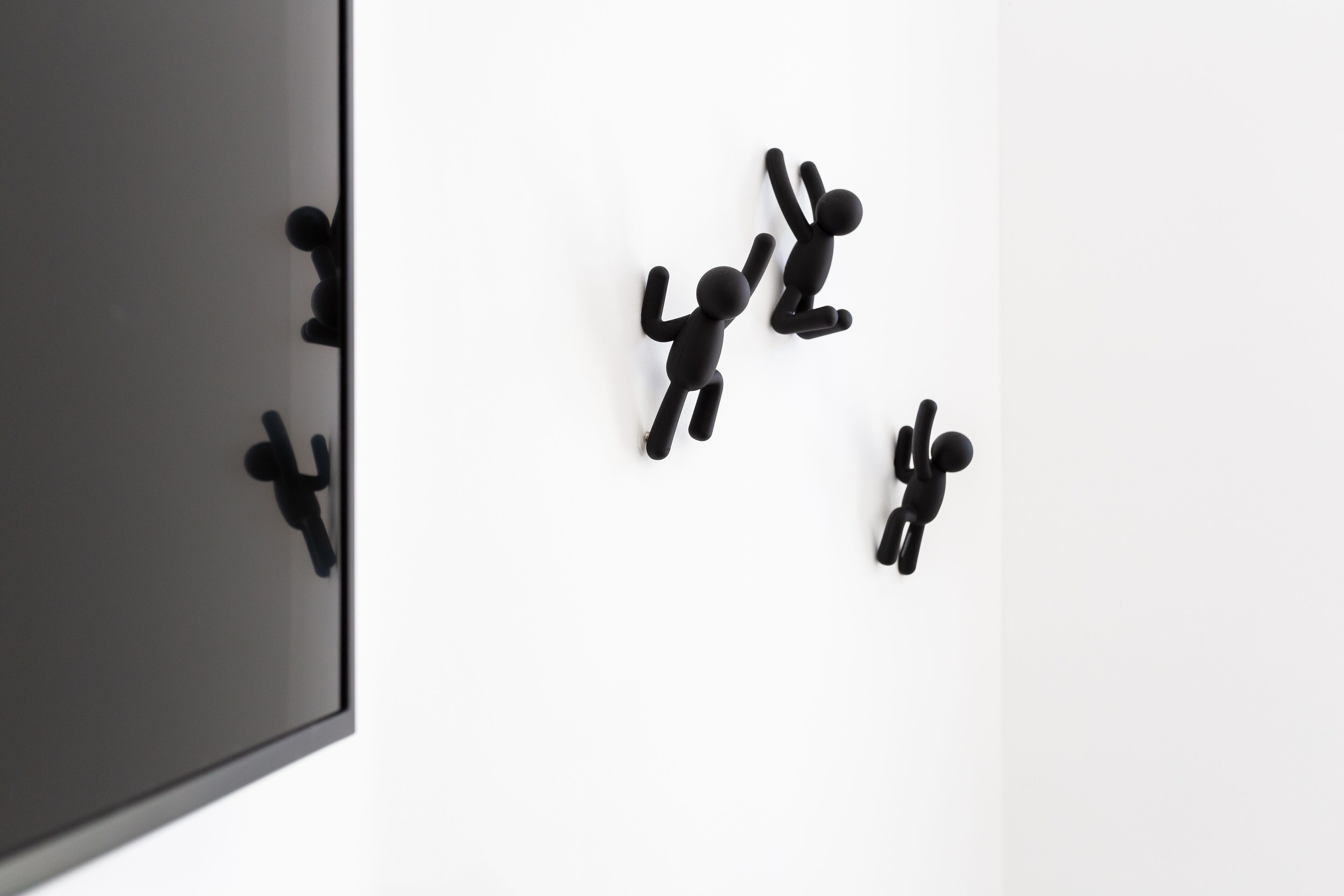 Un mur orné de quatre figures abstraites noires.