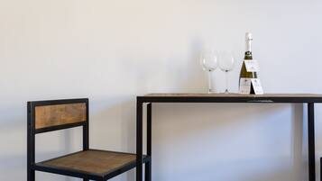 Une chaise et une table avec deux verres à vin et une bouteille de vin.