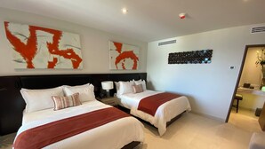 A hotel room with two beds, a large abstract painting, a decorative wall piece, and a modern bathroom visible through an open door. - Corazón Resort&Spa: 2BR Corazon Suite w/ private hot tub, ocean view, sleeps 8 (Cabo San Lucas)