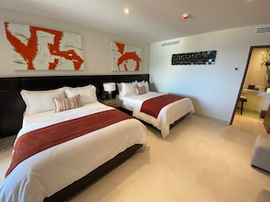A hotel room with two beds, a large abstract painting, a decorative wall piece, and a modern bathroom visible through an open door. - Corazón Resort&Spa: 2BR Corazon Suite w/ private hot tub, ocean view, sleeps 8 (Cabo San Lucas)
