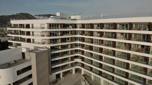 A multi-story hotel with a modern architectural design, featuring balconies with seating and a central courtyard. - Corazón Resort&Spa: 2BR Corazon Suite w/ private hot tub, ocean view, sleeps 8 (Cabo San Lucas)