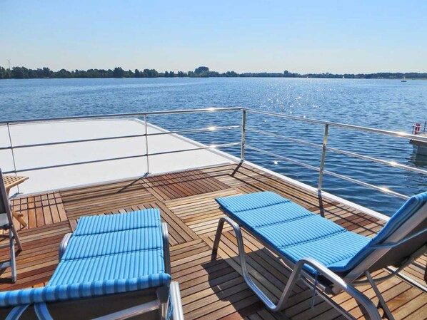 Relax on the deck with a clear view of the water and distant shoreline.