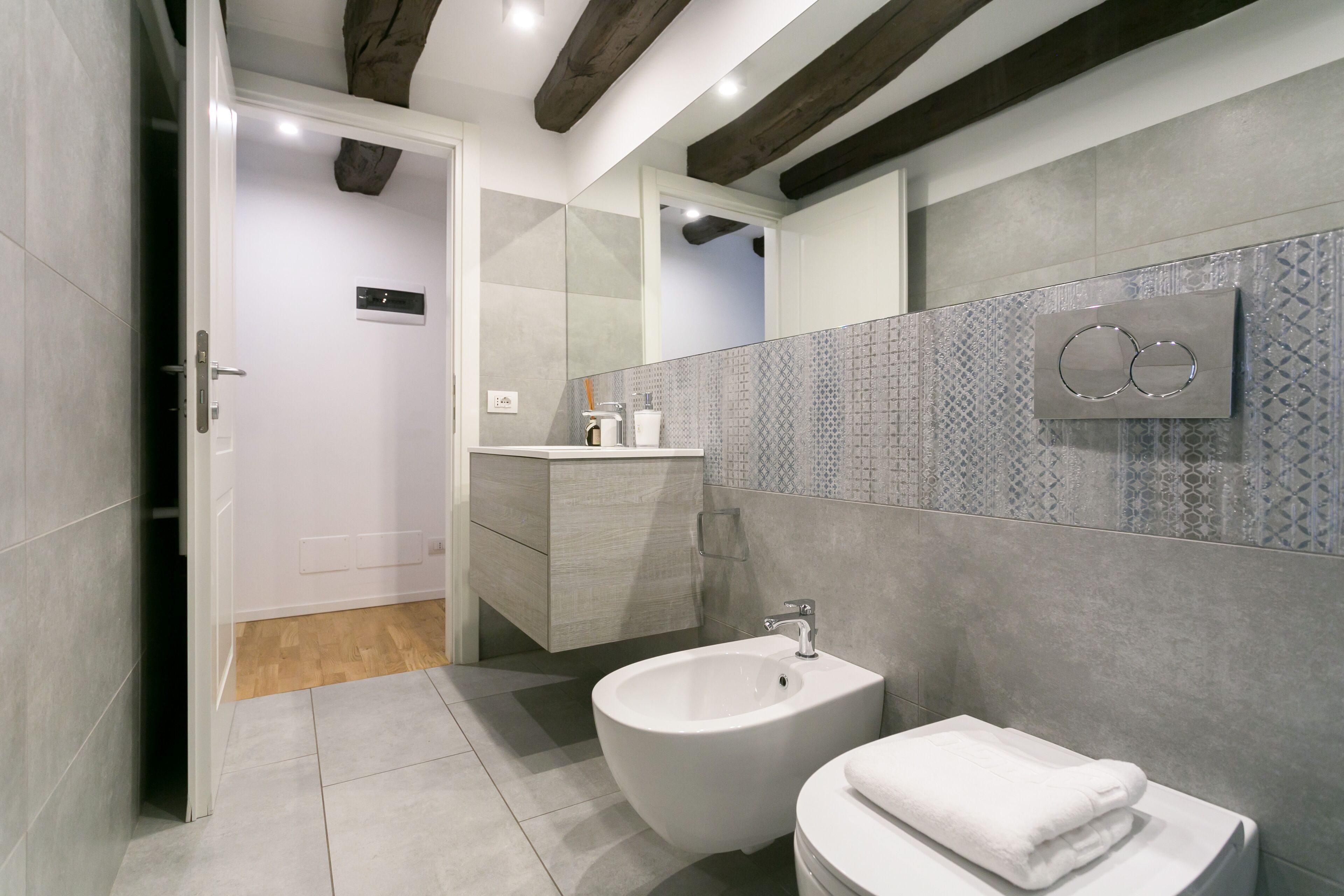 A modern bathroom with a bidet, a toilet, and a vanity.