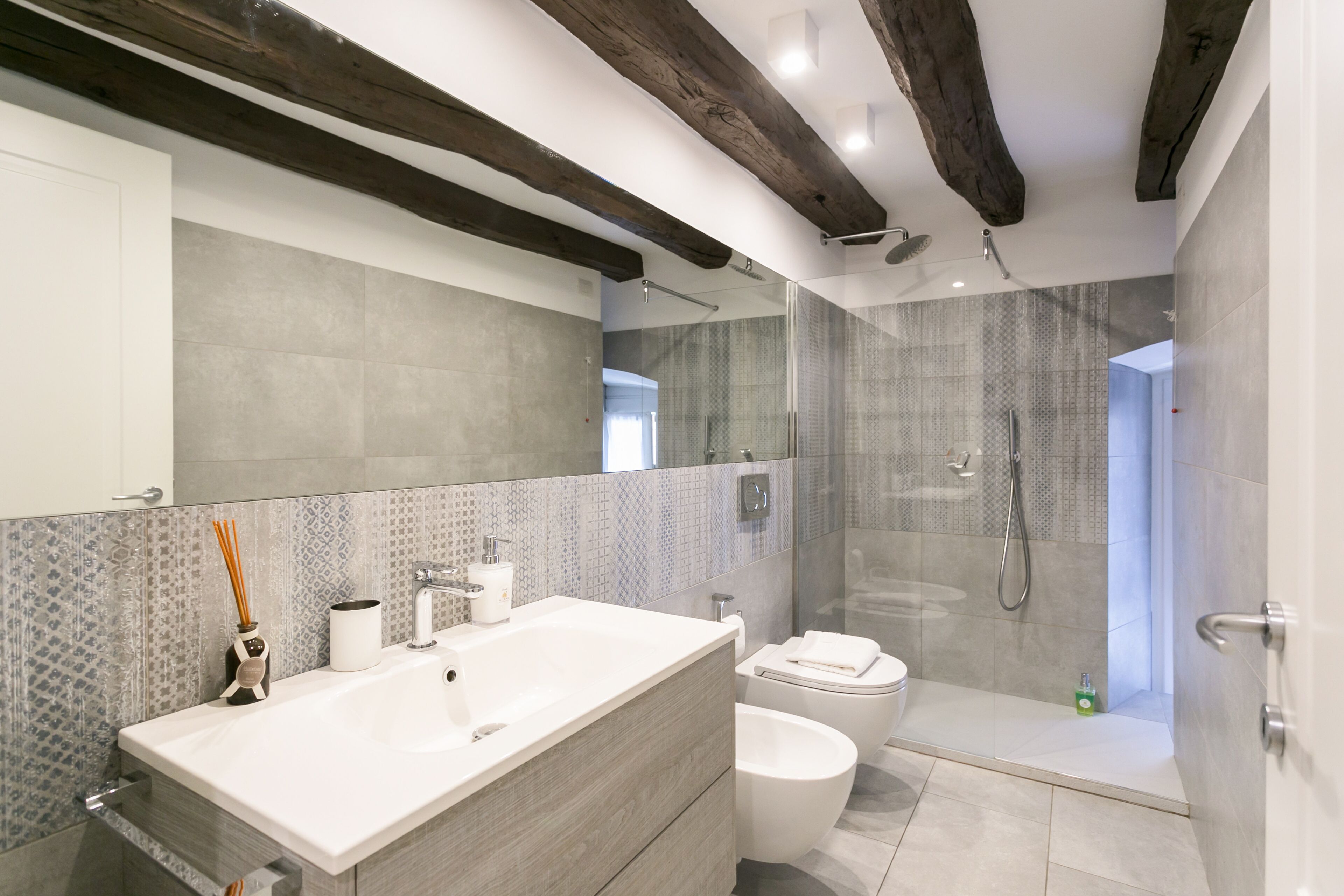 A modern bathroom with a large sink, toilet, and shower area.