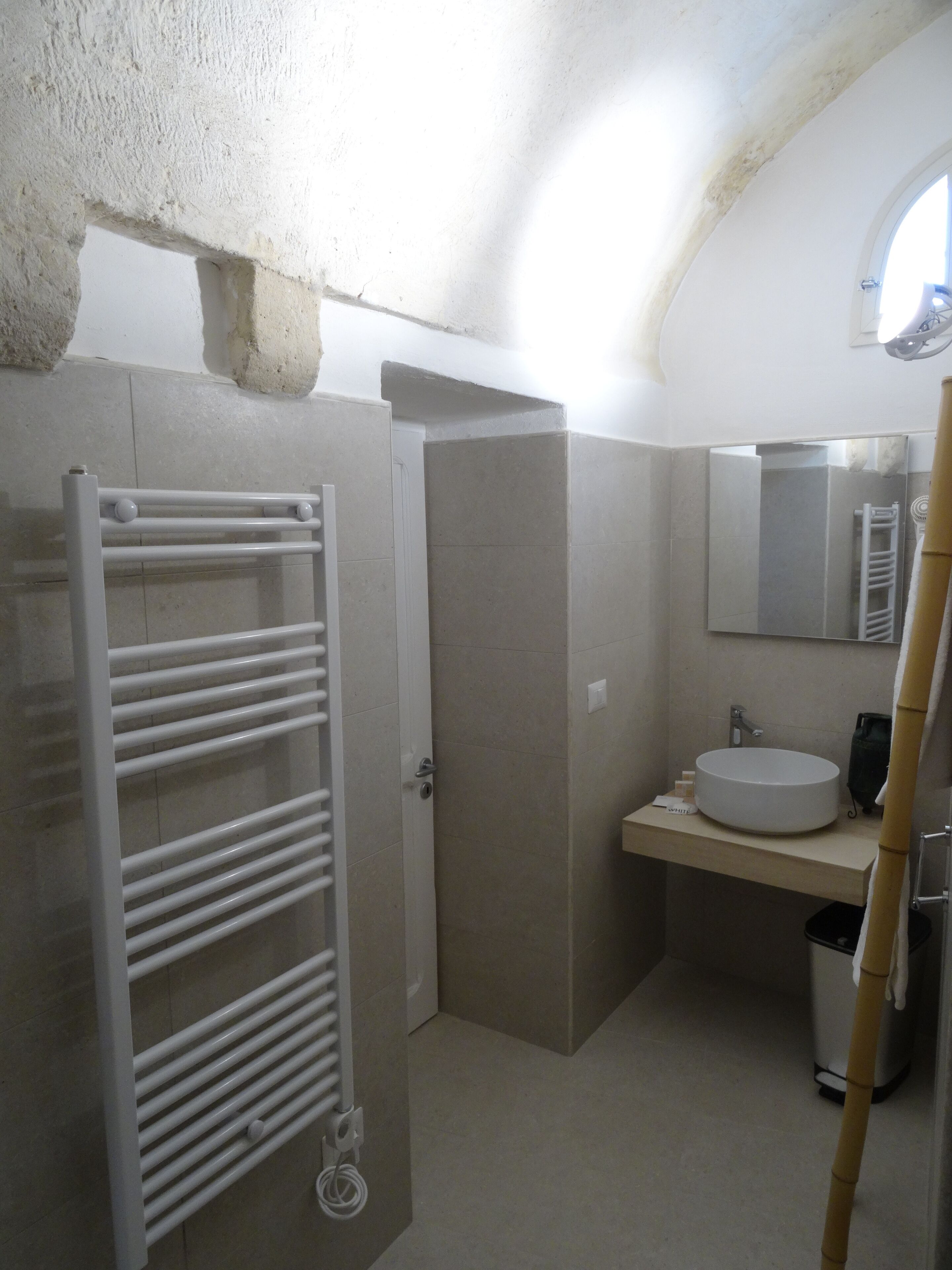 A bathroom with a white bathtub, a sink, and a towel rack.