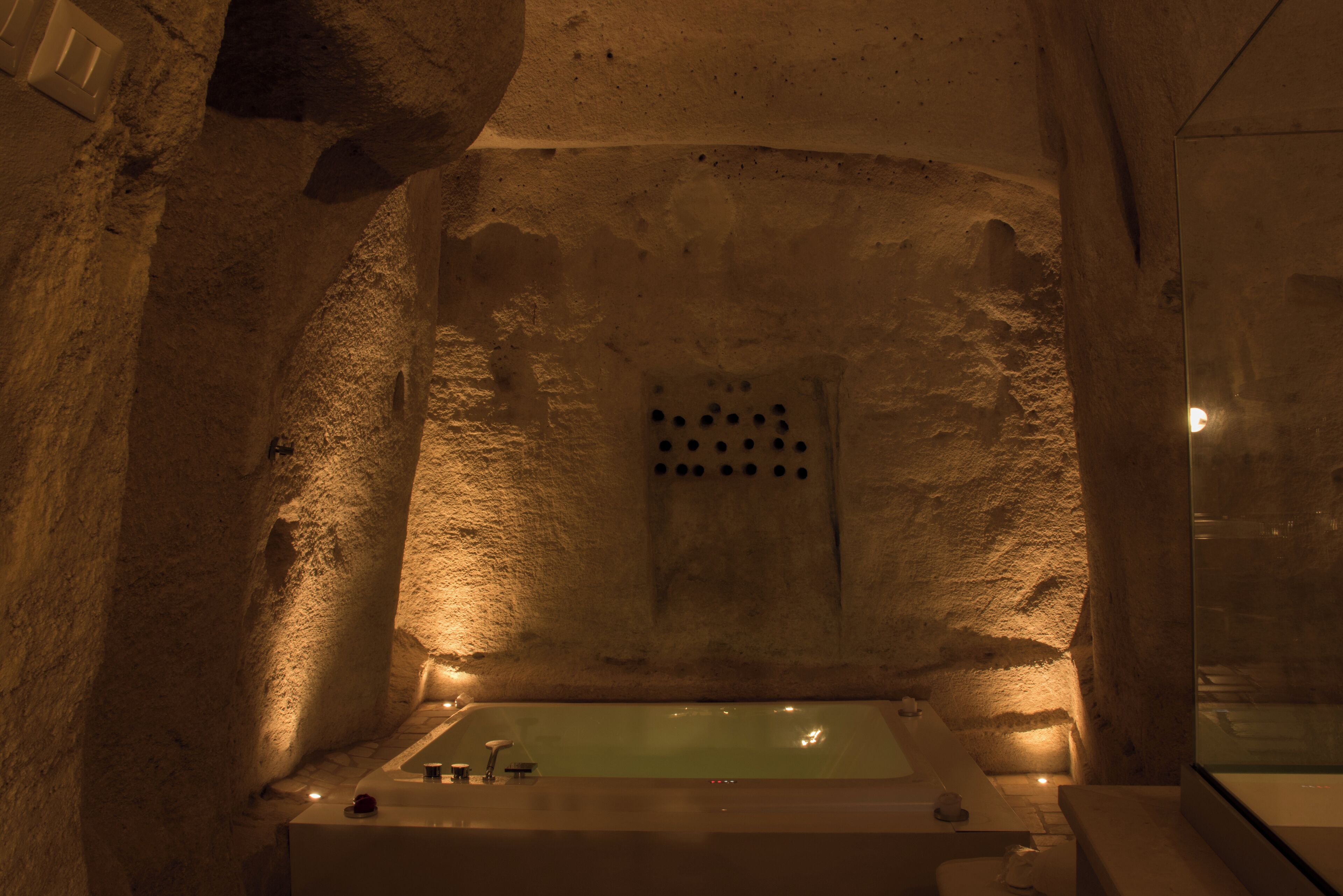 A stone-walled room with a bathtub.
