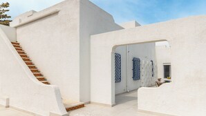 Un bâtiment moderne à l’extérieur blanc, doté d’un escalier et d’une porte aux motifs rayés.