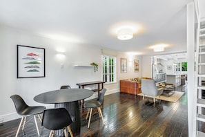 Ein modernes Interieur mit Essbereich, Küche und einer Treppe.