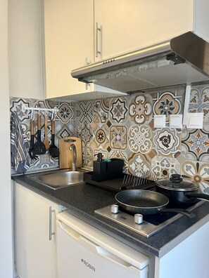 Refrigerador, parrilla de estufa, utensilios de cocina y condimentos