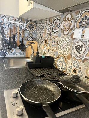 Refrigerador, parrilla de estufa, utensilios de cocina y condimentos 