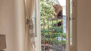 A room with a view of a garden through a metal gate. - Domus 1333 Ortigia Holidays (Siracusa)
