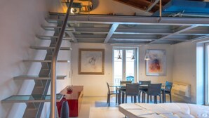 A modern interior with a staircase, dining area, and seating. - La Boheme di Ortigia (Siracusa)