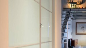 A modern interior with a glass partition, a staircase, and a bookshelf. - La Boheme di Ortigia (Siracusa)