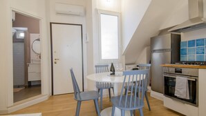 Eine kompakte Küche mit Essbereich, einem eingebauten Backofen und einem Fenster über der Spüle.