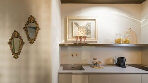 A kitchen with a sink, two ornate mirrors, a framed artwork, and a coffee maker. - Maisonnette V.V.155 Ortigia Holidays (Siracusa)