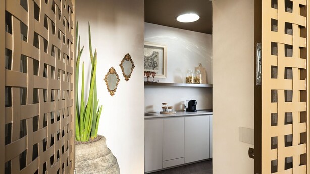 A kitchen with white cabinets, a coffee maker, and decorative items on the counter. - Maisonnette V.V.155 Ortigia Holidays (Siracusa)