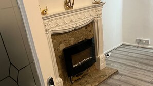 Une pièce avec une cheminée, une porte et un plancher en bois.