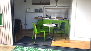 Une cuisine compacte avec un coin repas comprenant une table et des chaises, un petit four et un évier.